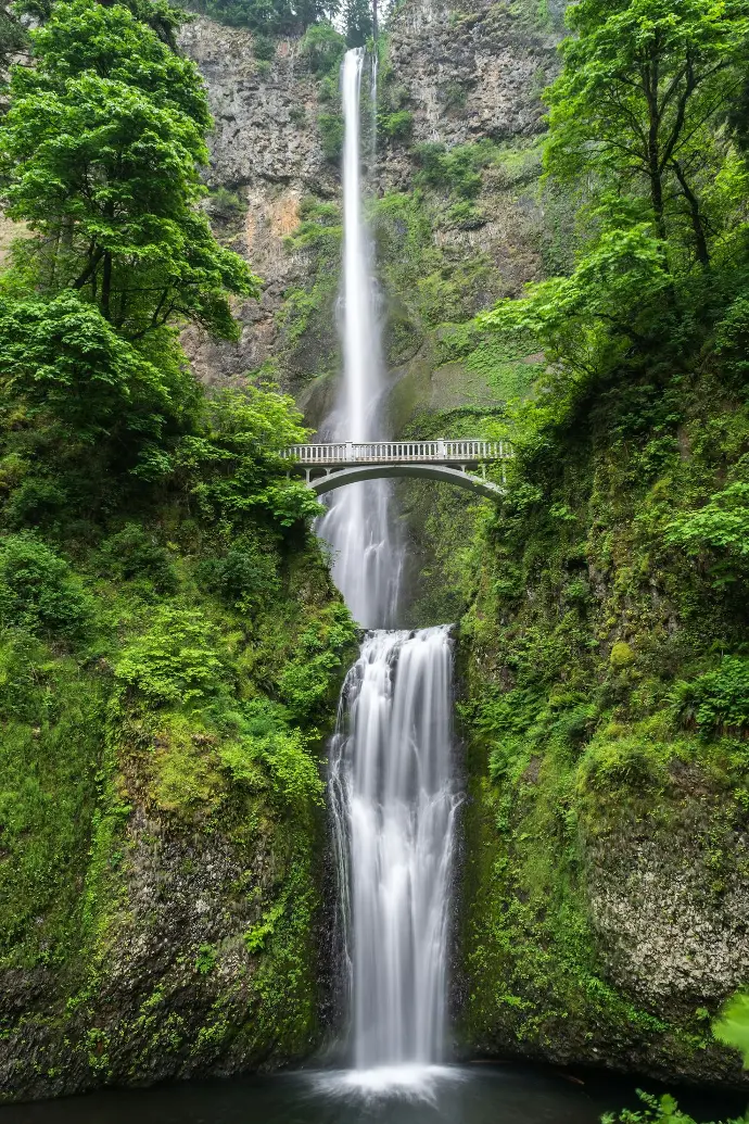 gray concrete bridge and waterfalls during daytime